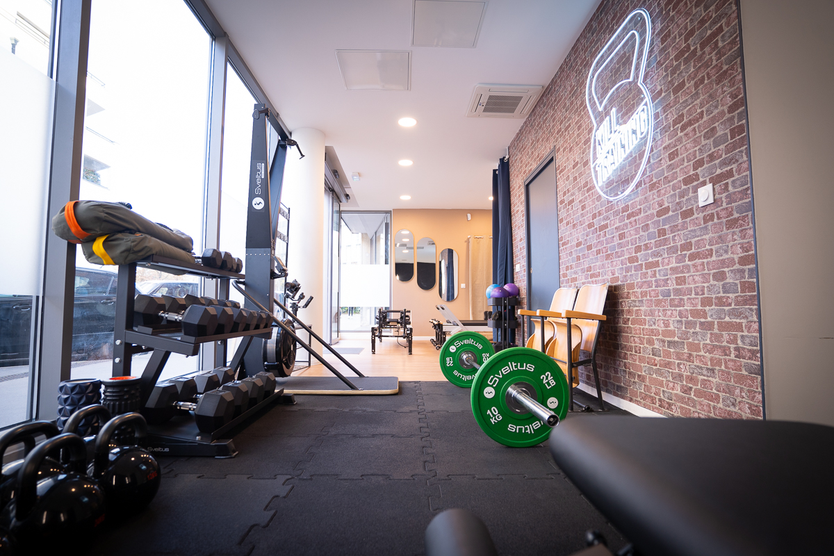 Intérieur du studio de fitness montrant l'équipement d'entraînement et l'espace